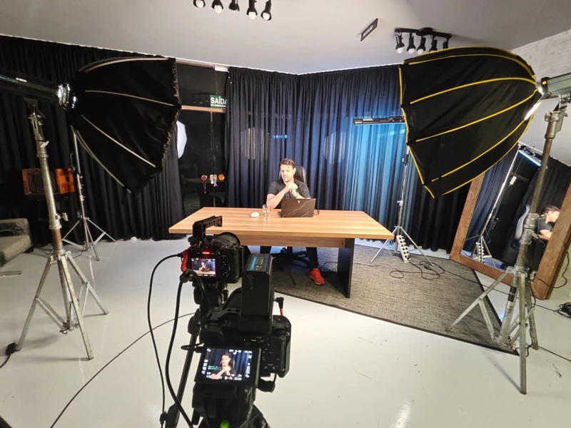 Apresentador gravando em estúdio, com câmeras e iluminação preparadas.